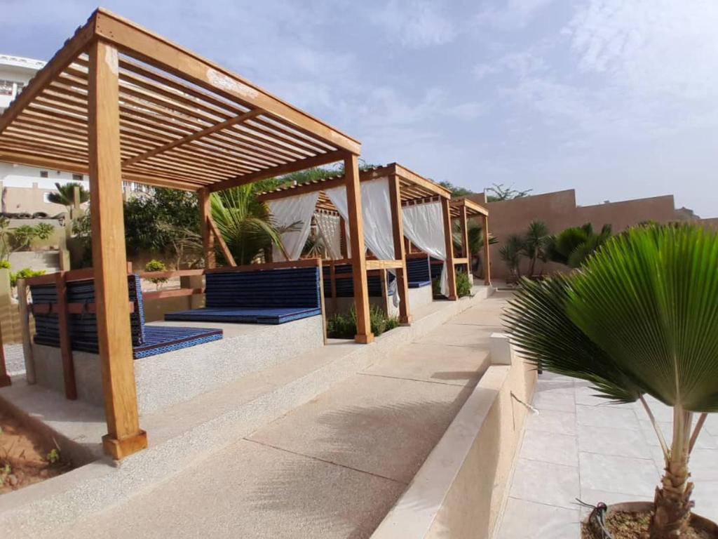 土巴迪亚劳La Villa d'O的凉亭,凉亭,有蓝色长椅和棕榈树