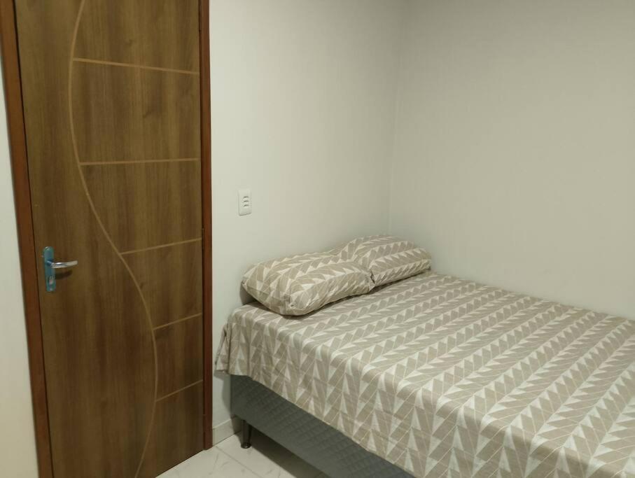 贝伦Apartamento novo e confortável的一间卧室配有一张床和一扇木门