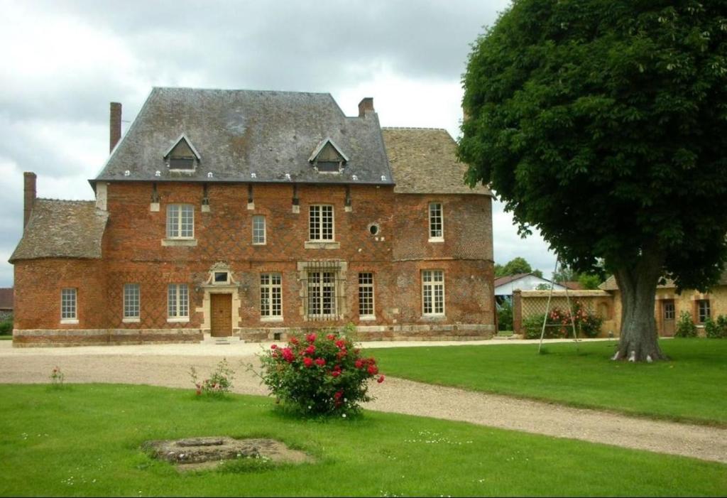 Manoir du Petit Logis的前面有一棵树的大砖房子