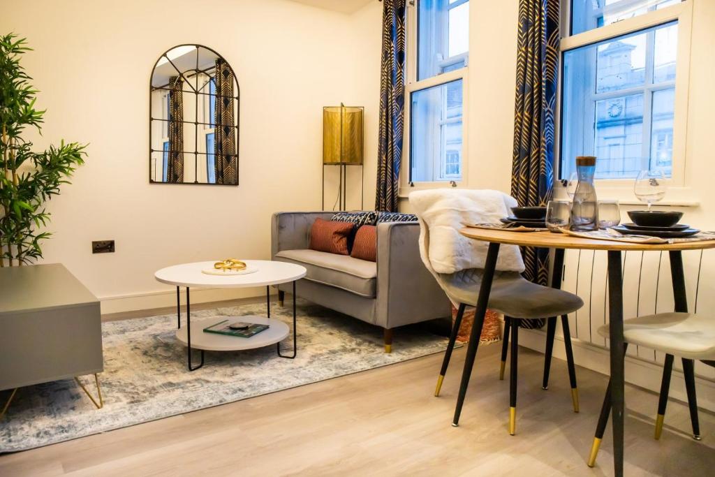 利兹Kirkgate Suites - Stylish City Centre Apartment的客厅配有沙发和桌子