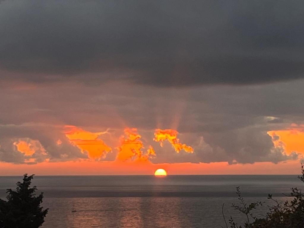 巴尔SeaAdrik的太阳隐藏在云层后,在海洋上方的日落