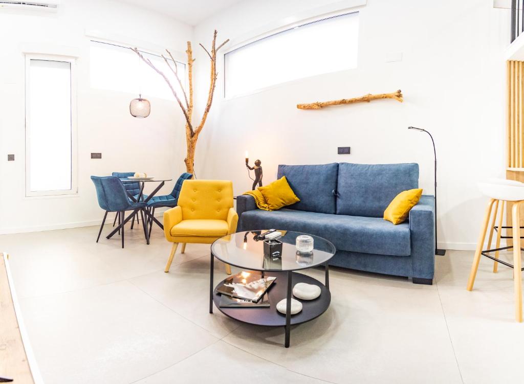 穆尔西亚Loft 11 A的客厅配有蓝色的沙发和黄色的椅子