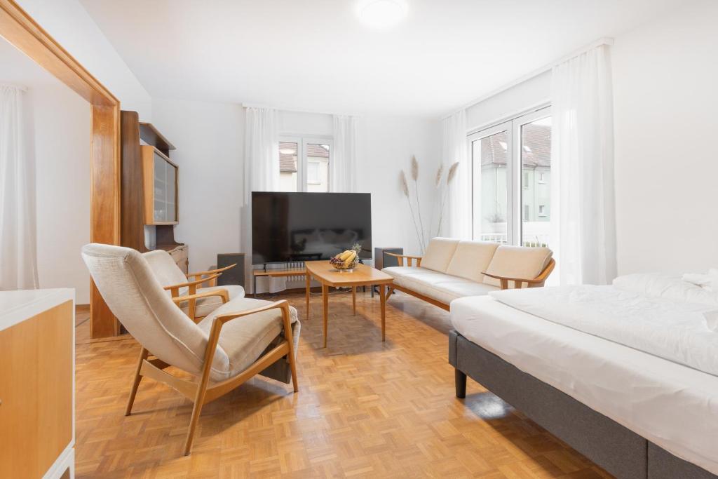 博登斯边的拉多夫采尔Bodensee-Haus IStayUnixI Seenähe-Terrasse-Garten-Netflix-Parkplatz的客厅配有床、沙发和电视。