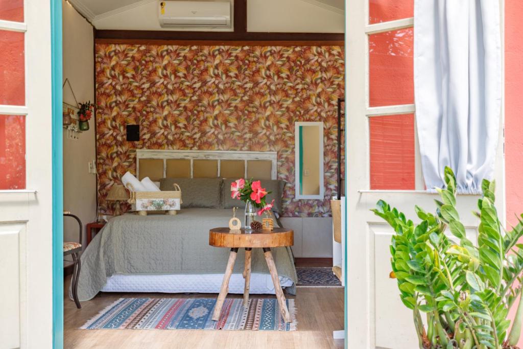弗洛里亚诺波利斯Paradise Bangalô的一间卧室配有一张床和一张鲜花桌子