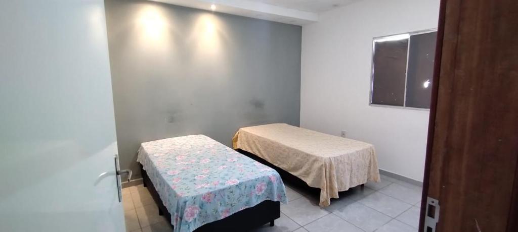 加拉尼温斯QUARTO COM BANHEIRO PARA ALUGAR POR DIÁRIA的一间医院间,设有两张床和窗户