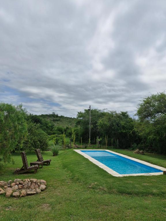 坦季El Rincon de Jose Luis - Cabañas y Restaurante的一个带两把椅子的庭院内的游泳池