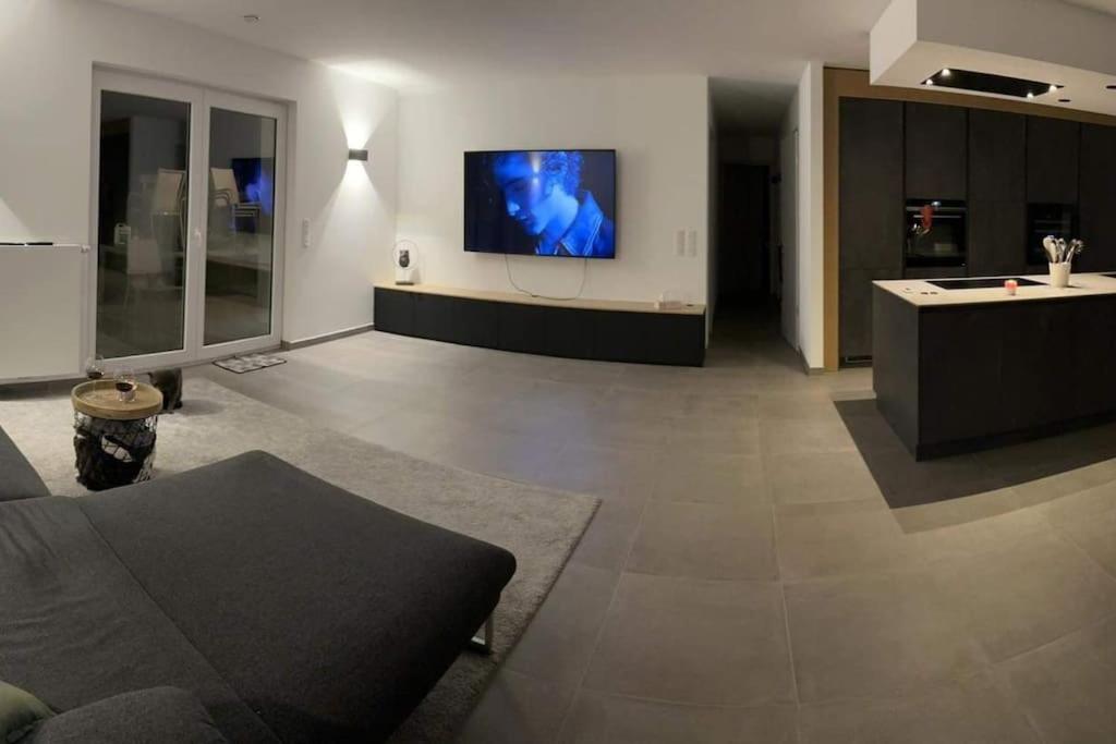 Le rez de chaussée de chez Jade的客厅配有沙发和墙上的电视