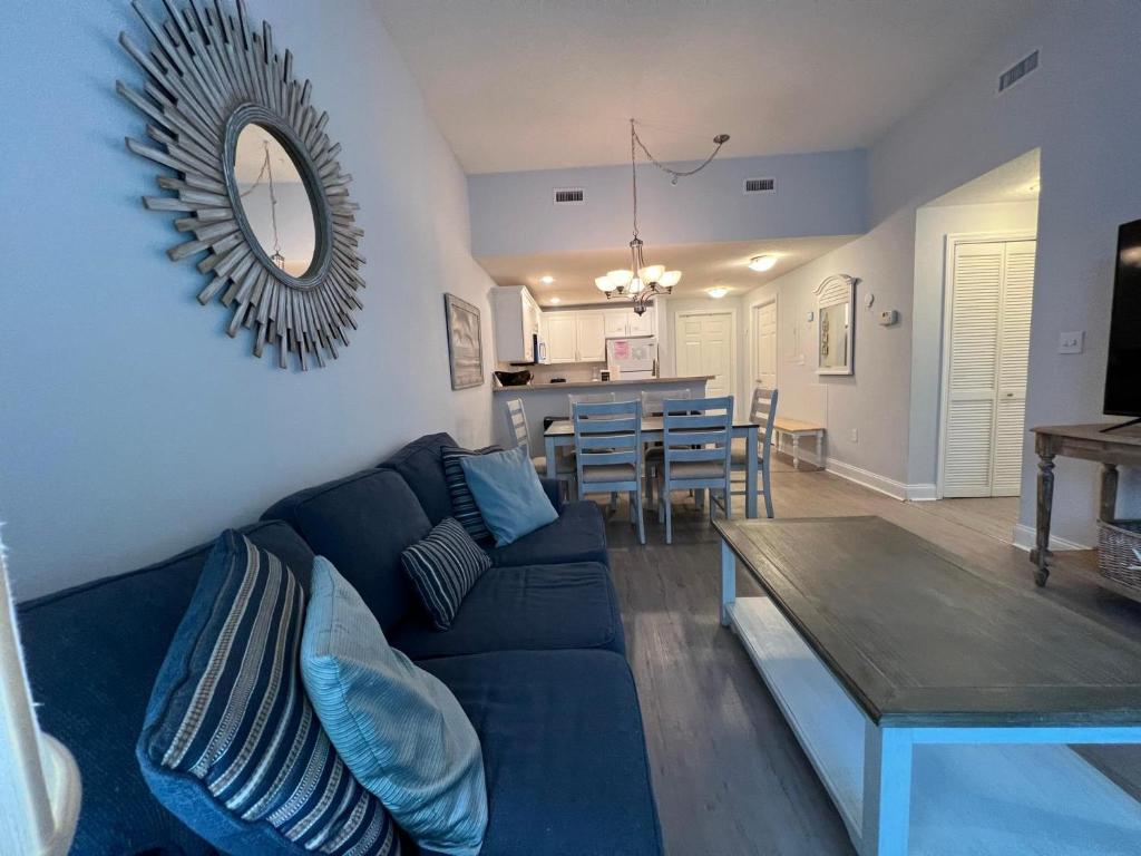 默特尔比奇2501 S Ocean Blvd, 1215 - Ocean View Sleeps 8的客厅配有蓝色的沙发和桌子
