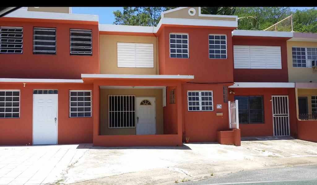 圣胡安San Juan apartments new的红色和黄色的房子,有车道