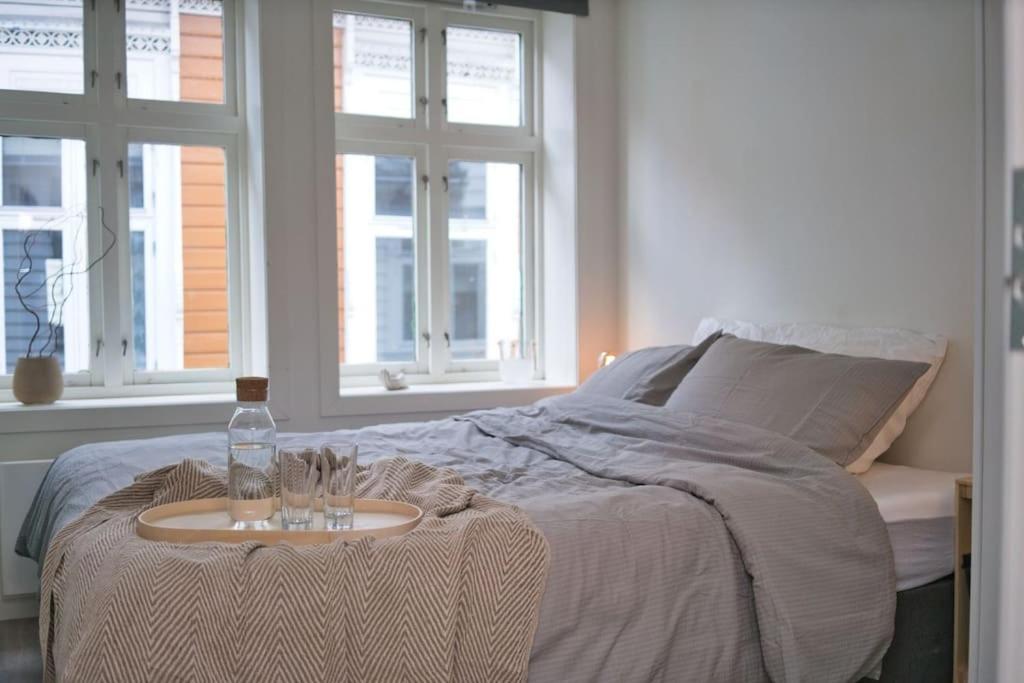 卑尔根Vestre Murallmenningen的一间卧室配有一张带桌子和一瓶水的床