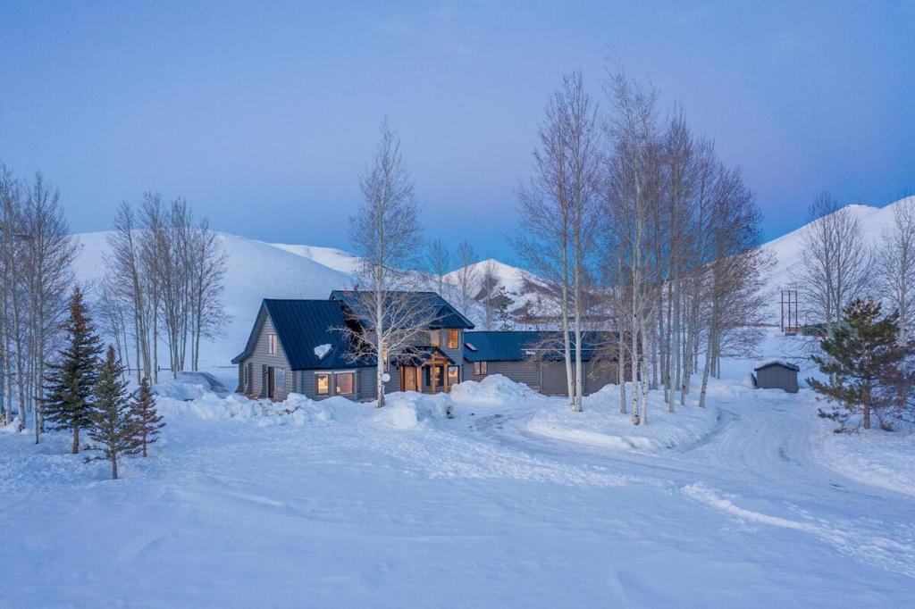 黑利Gorgeous Log Cabin Close to Town with Hot Tub的雪中带蓝色屋顶的房子