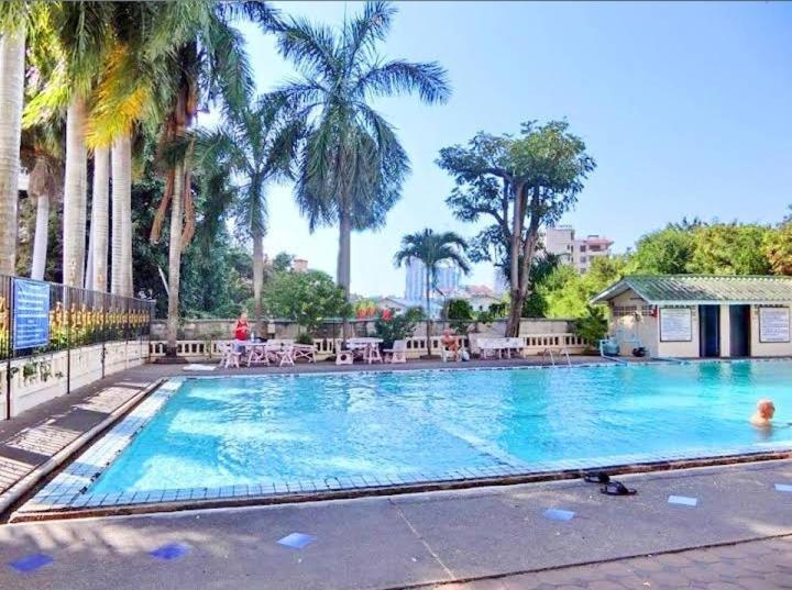 芭堤雅市中心Niran Grand Ville A4F的度假村内一座种有棕榈树的大型游泳池