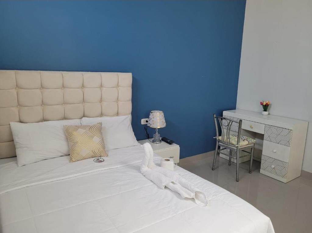 皮斯科CASA MARIA的一间卧室配有一张白色大床和蓝色的墙壁