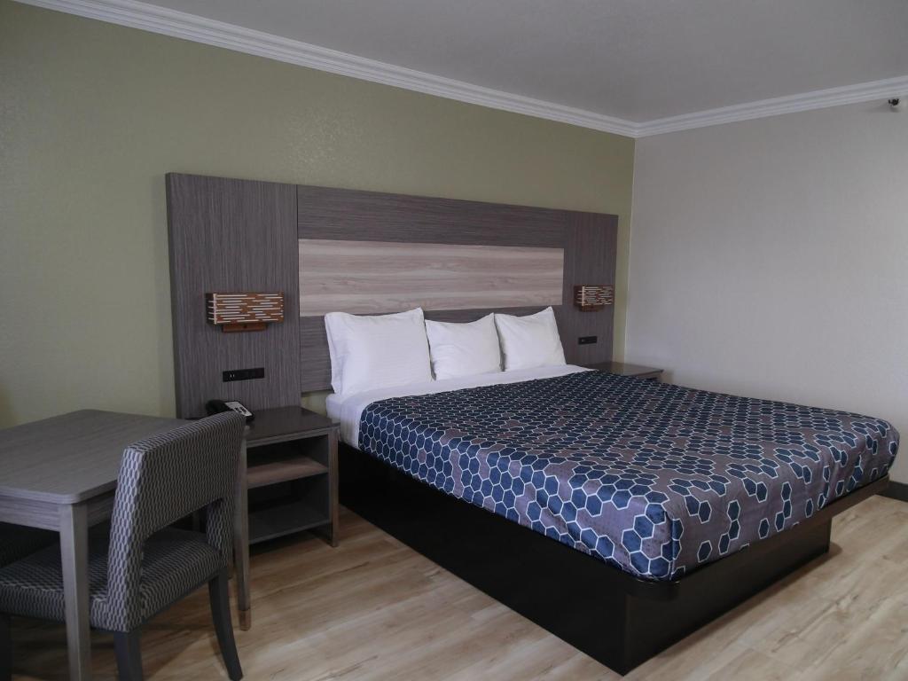 里亚托里阿尔托美国最有价值旅馆的一间卧室配有一张床、一张桌子和一张书桌