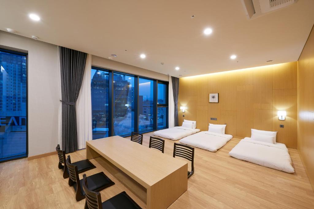 光州CS Hotel的一间设有两张床和一张桌子及椅子的房间