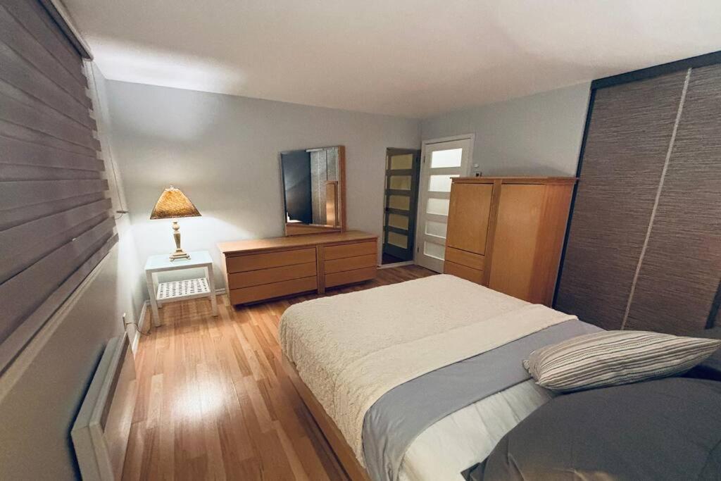 拉瓦尔Ahava, Centropolis Laval的一间卧室配有一张床、梳妆台和镜子