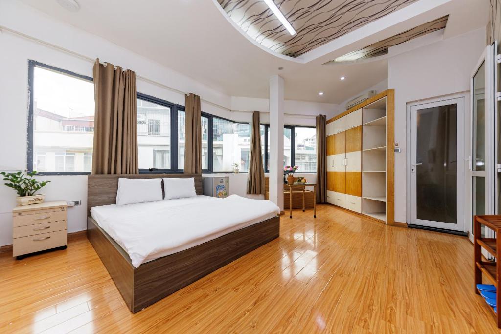 河内Lamaison Hà Nội的一间卧室设有一张大床,铺有木地板。