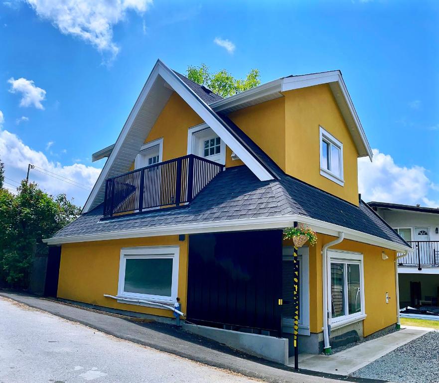 温哥华Vancouver’s Homey Laneway House的街道上带阳台的黄色房屋