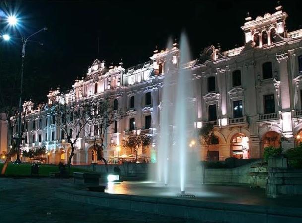 利马Duplex in historical heart of the Plaza San Martín的一座建筑,在晚上前方有一个喷泉