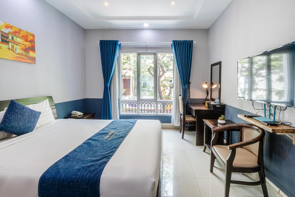 胡志明市La Serena Boutique Hotel的一间卧室配有一张床、一张书桌和一个窗户。