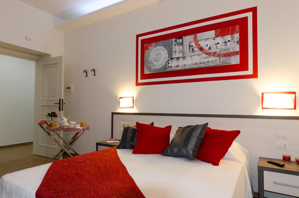 罗马罗马杰梅迪旅馆的卧室配有带红色枕头的大型白色床