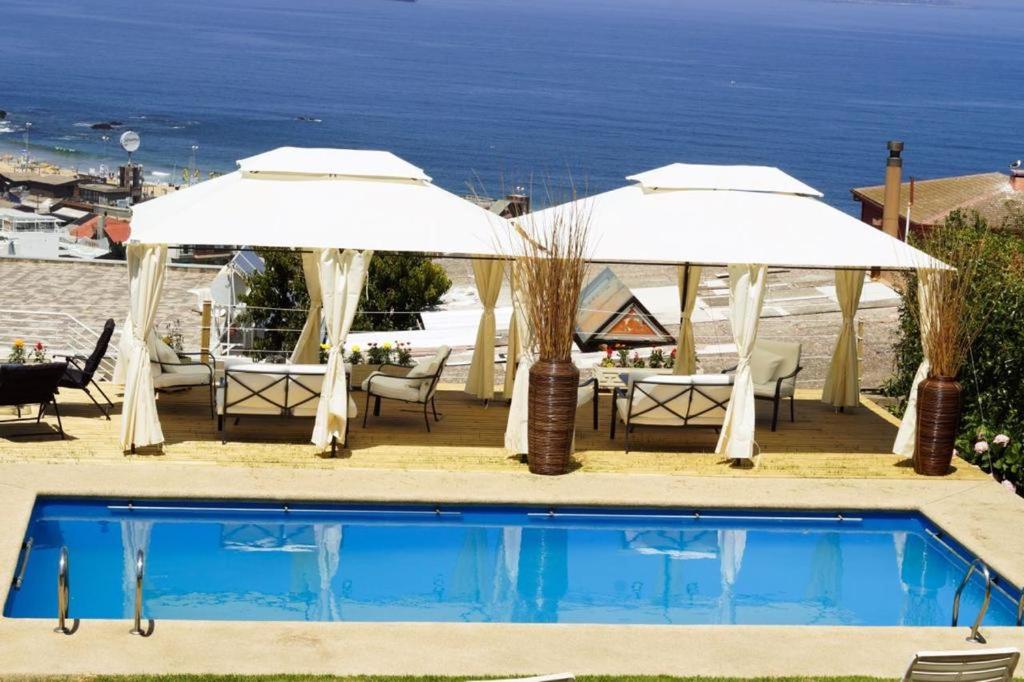 维纳德马FINTUPS SPA的一个带两把遮阳伞和一张桌子及椅子的游泳池
