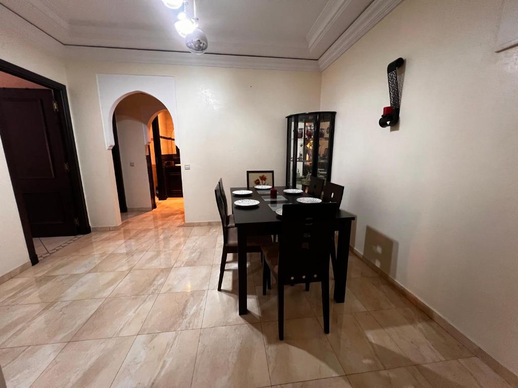 马拉喀什Magnifique, Appartement, familial, spacieux 2chambres salon salle à manger的一间用餐室,配有黑色的桌子和椅子