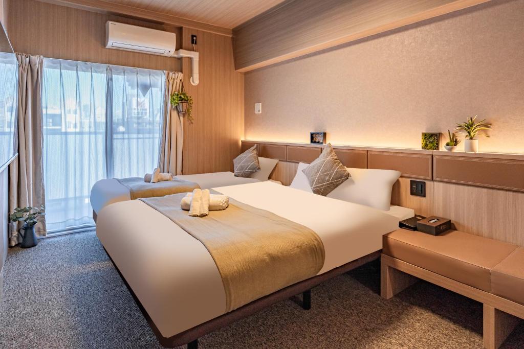大阪住一道顿堀2号店的酒店客房设有两张床和窗户。