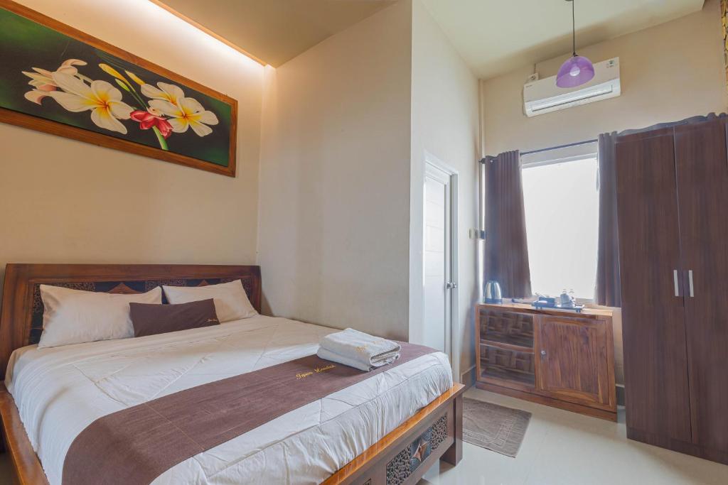 马塔兰Jepun Guest House的一间卧室设有一张床和一个窗口