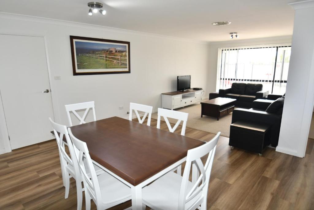 达博Ascot Gardens Serviced Apartments的用餐室以及带桌椅的起居室。