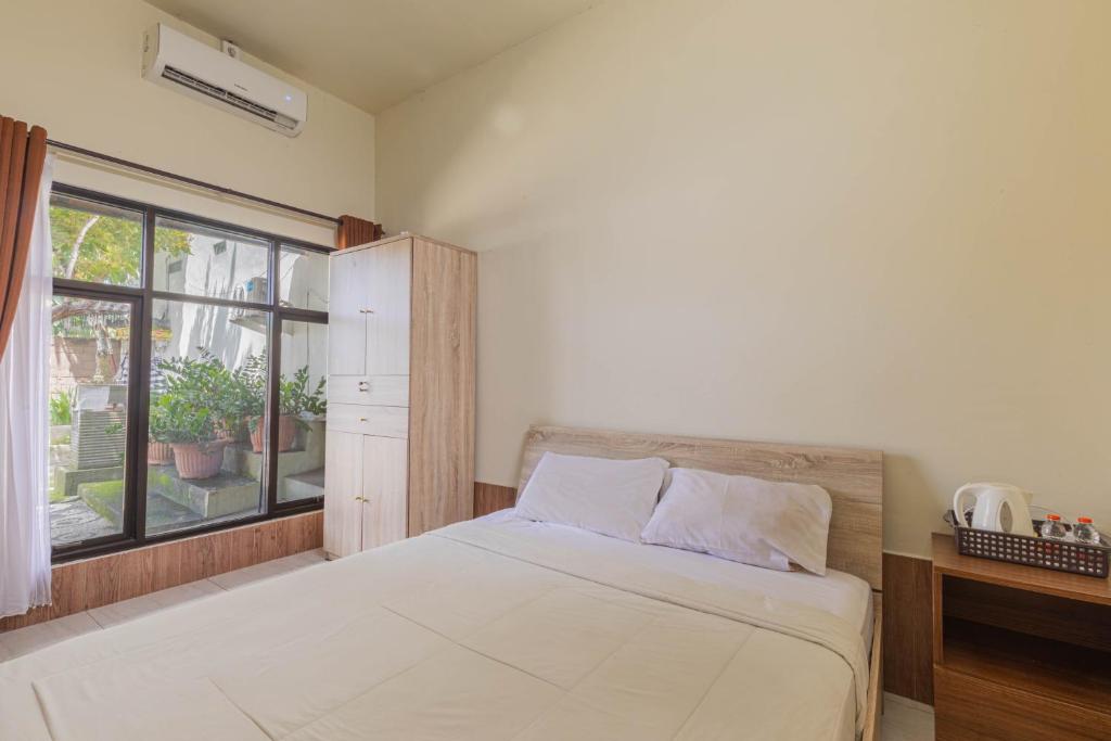 马塔兰Penginapan Asri的一间卧室设有一张大床和一个窗户。