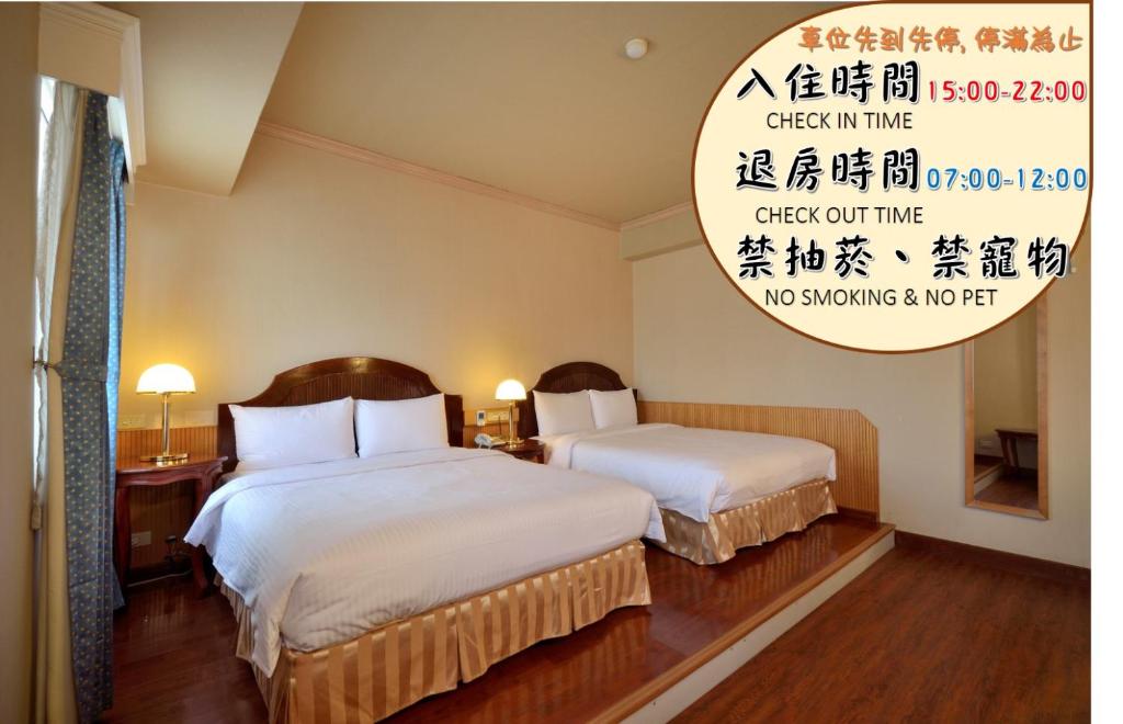高雄歌德商旅的酒店客房,设有两张床和标志