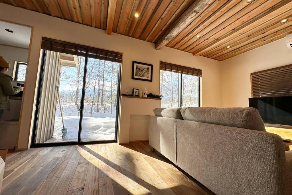 白马村The Misorano Cottage的带沙发和滑动玻璃门的客厅