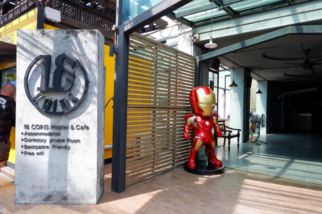 芭堤雅市中心18 Coins Budget Hotel的一座建筑前的超级英雄雕像