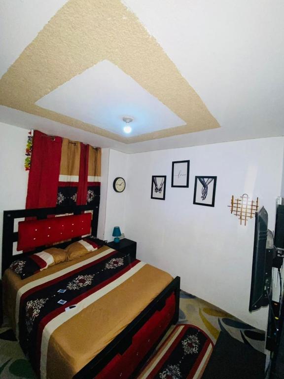 海地角Juju Boutique & House的一间卧室配有一张红色床头板的床