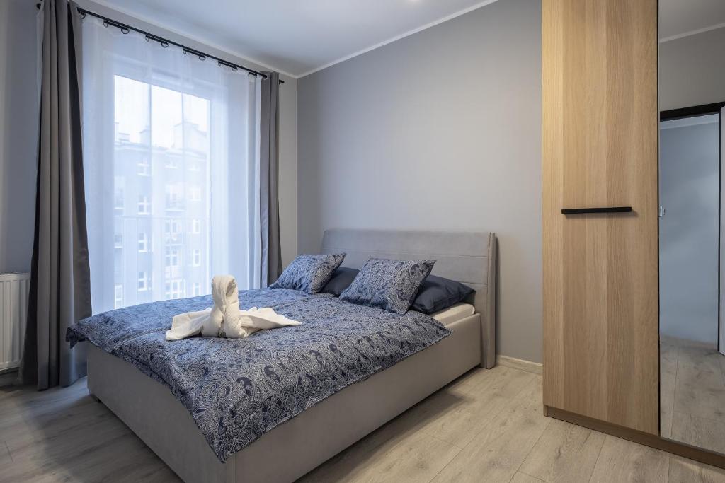 格丁尼亚02 Gdynia Premium - Apartament Mieszkanie dla 4os的卧室里设有一张床,上面有一只动物