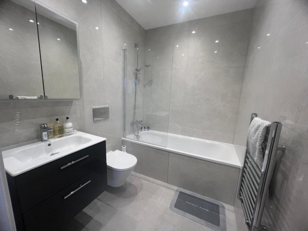 里克曼斯沃斯New build 1 bedroom modern apartment Rickmansworth的带浴缸、卫生间和盥洗盆的浴室