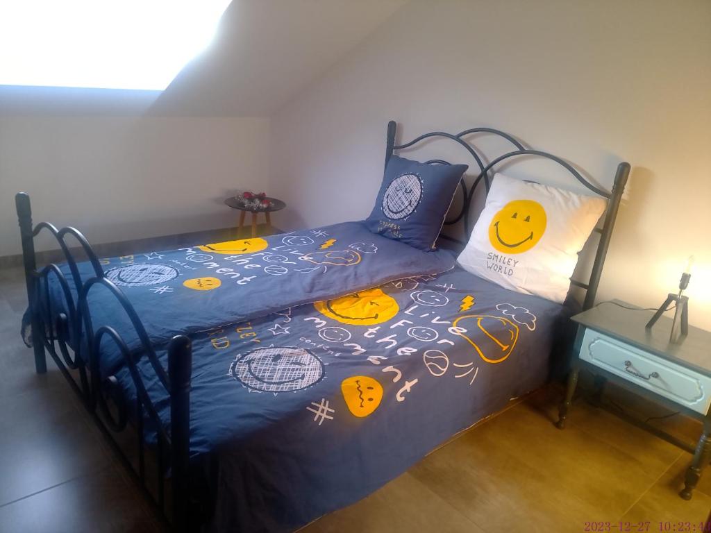 L'ECUREUIL的一间卧室配有一张带蓝色棉被和枕头的床