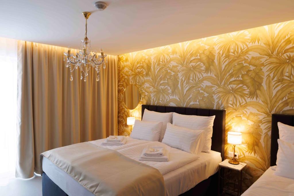 日利纳Villa Mala Praha Experience in the Center of Žilina的卧室配有一张带吊灯的大型白色床。