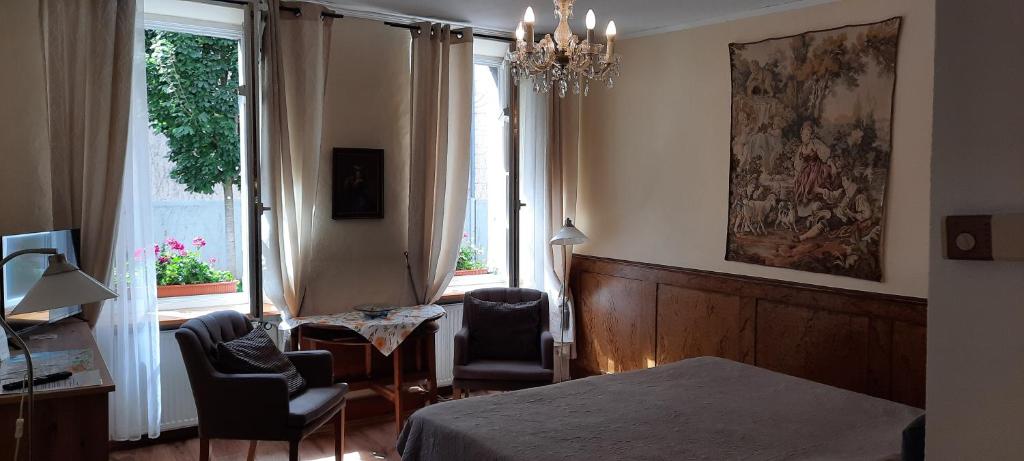 美因茨罗素街老城公寓的一间卧室配有一张床、两把椅子和一个窗户