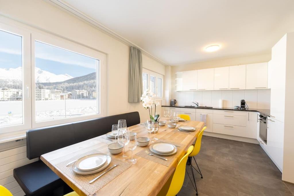 圣莫里茨Idyllic apartment in St. Moritz的一间带桌椅的用餐室和一间厨房