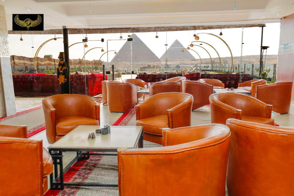 开罗New Comfort Inn Giza的一间设有桌椅和金字塔的餐厅