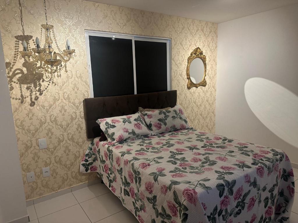 Paulo AfonsoApt Real的一间卧室配有一张带花卉棉被的床