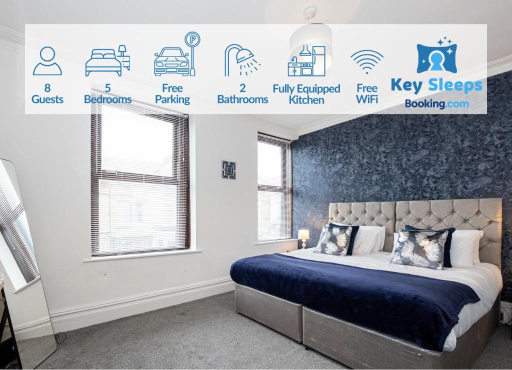 莫克姆Spacious & Stylish 5 Bed with Free Street Parking的一间卧室设有床铺和配有标志的墙壁