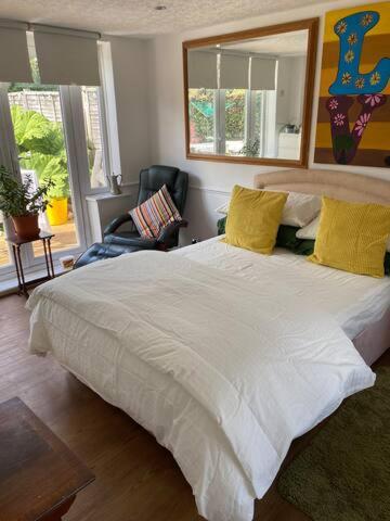 珀利Pond Cottage的卧室配有一张带黄色枕头的大型白色床。