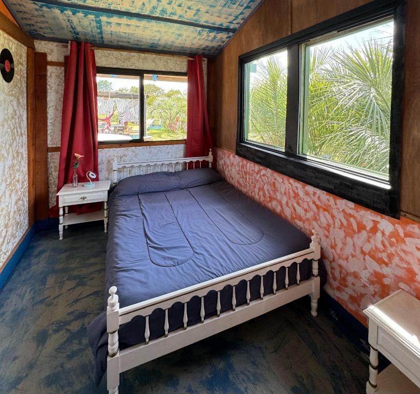 拉佩德雷拉Biodiversidad posada familiar的配有2扇窗户的客房内的1张床