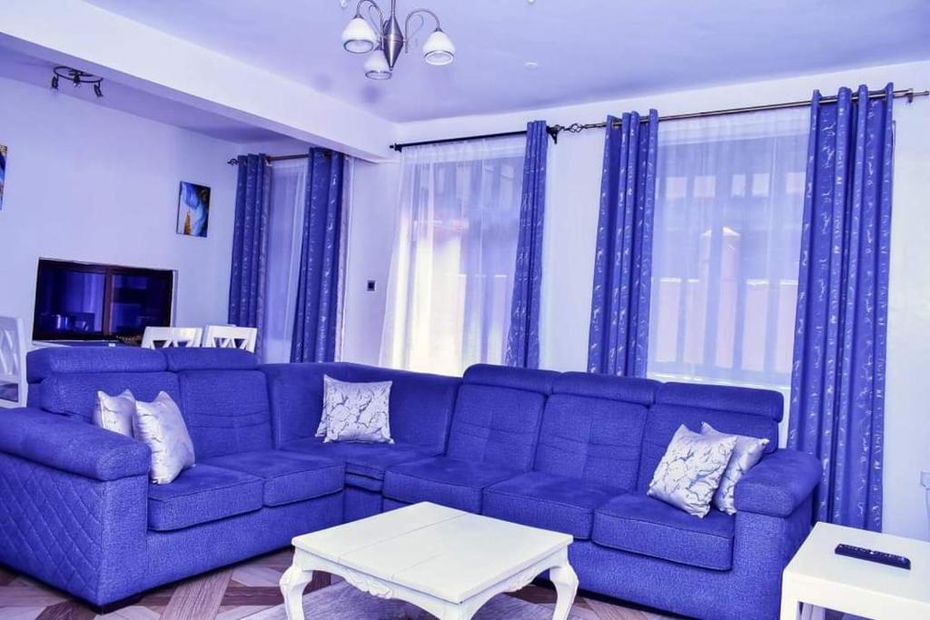 基苏木Motema AirBnB的客厅配有蓝色窗帘的蓝色沙发