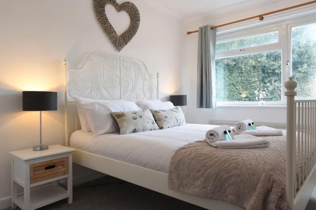 AlverstokeSpacious Family Home Sleeps 6的卧室配有一张白色的床,上面有两只填充动物