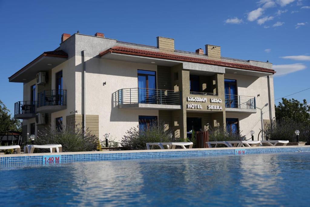 第比利斯Sierra Hotel Tbilisi的大楼前带游泳池的房子