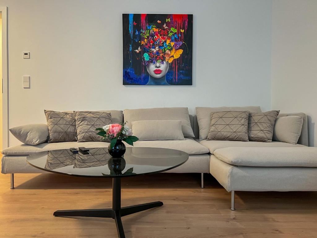 耶拿Appartement House Jena的客厅配有沙发和带绘画的桌子